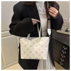 Détail du sac en cuir blanc avec imprimés cartoon et large bandoulière géométrique