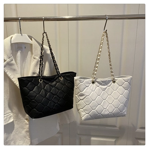 Vue détaillée des sacs fourre-tout matelassés noir et blanc avec chaînes dorées chic