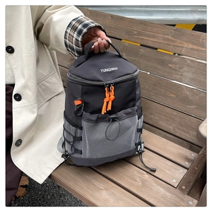 Detail of outdoor backpack featuring orange zipper pulls and side mesh storage pocket