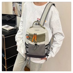 Outdoor sports backpack with mesh pocket and orange zippers in a lifestyle setting