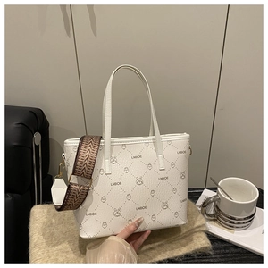 Détail du sac cabas blanc imprimé avec motifs de dessins animés et bandoulière ethnique