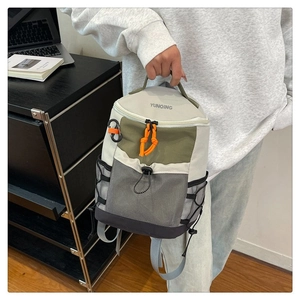 Detail of outdoor backpack featuring mesh pocket and orange cord zippers for hiking