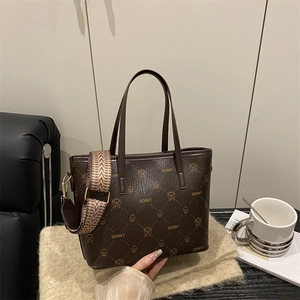 Sac cabas marron à motif lapin avec large bandoulière posé sur un tapis moelleux