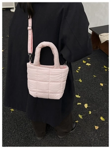 Detail of pink quilted crossbody bag with adjustable strap and soft puffer texture