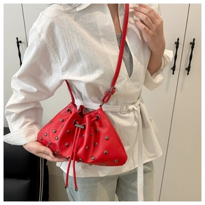 Close-up of bright red bucket bag with silver rivet studs and drawstring closure