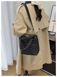 Quilted puffer crossbody bag in black nylon with adjustable shoulder strap on a model