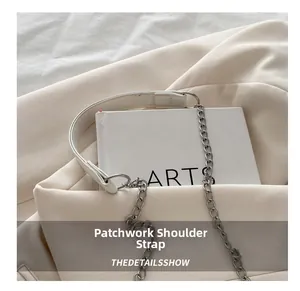 Detail of cream crossbody bag featuring a mixed silver chain and leather shoulder strap