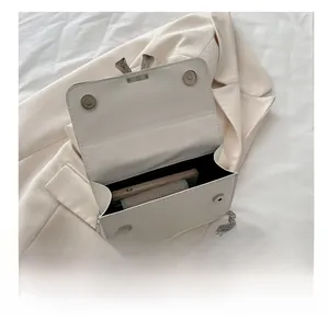 Internal view of white leather crossbody bag showing phone storage and magnetic clasp