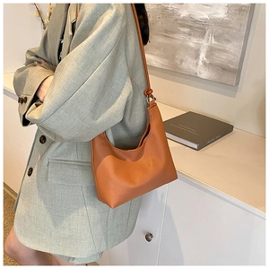 Close-up of brown lychee texture faux leather hobo bag with adjustable thin strap