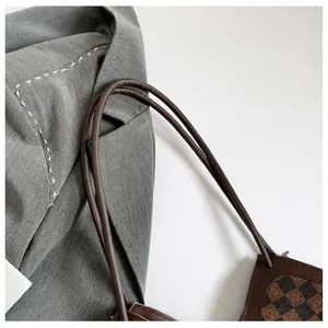 Detail van klassieke bruine ruitjes shopper met verfijnd handvat voor een zakelijke look