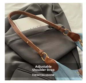 Detalle de correa ajustable de cuero marrón en bolso de hombro de mezclilla azul claro
