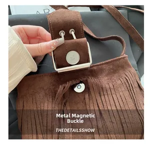 Dettaglio della chiusura magnetica argentata su borsa in pelle scamosciata marrone