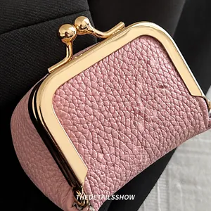 Close-up of pink lychee grain leather mini coin purse with gold metal clasp detail
