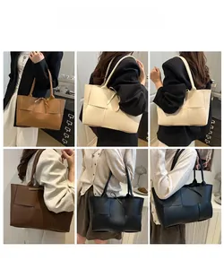 Vue détaillée de grands sacs cabas en cuir tressé en plusieurs couleurs sur l'épaule