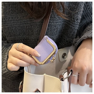 Dettaglio mini borsa in pelle viola con chiusura a scatto dorata e tracolla sottile