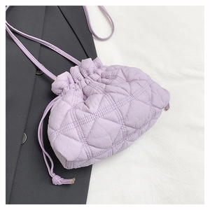 Detailed view of purple quilted rhombic texture and drawstring closure on bucket bag