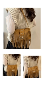Dettaglio di una borsa a tracolla in pelle scamosciata marrone con frange e nappine boho