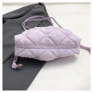 Detail view of light purple quilted nylon bucket bag with diamond stitching and side ties