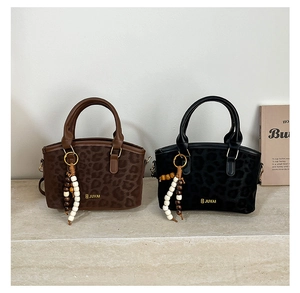 Detalle de bolsos con estampado de leopardo, colgantes de cuentas y logos metálicos