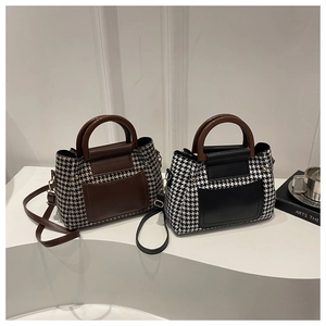 Λεπτομέρεια από ρετρό τσάντες με μοτίβο houndstooth, ξύλινες λαβές και μεταλλικά άγκιστρα