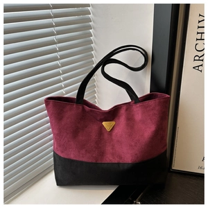 Bolso tote bicolor burdeos y negro en gamuza con placa metálica y diseño elegante