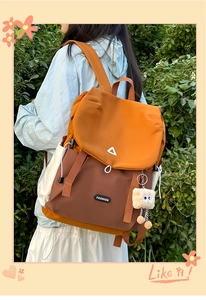 Outdoor-Aufnahme eines orange-braunen Reiserucksacks mit Schnalle und Plüschanhänger