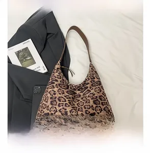 Detailed view of leopard print tote bag with brown straps and large interior capacity