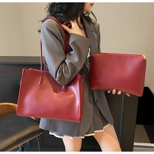 Detail of burgundy large tote bag with matching zippered pouch and smooth matte leather