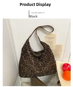 Close-up of leopard print fabric texture and wide shoulder strap on a large hobo tote bag