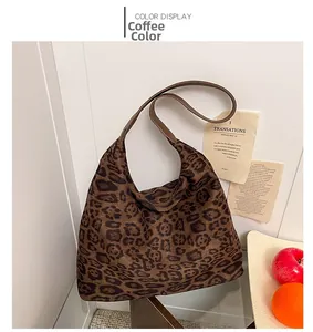 Detail view of coffee leopard print tote bag with wide leather strap against white wall