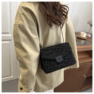 Détail du sac bandoulière avec texture léopard et bandoulière chaîne noir mat