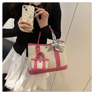 Detail of canvas tote bag with pink leather trim and scarf handle shown by mirror selfie