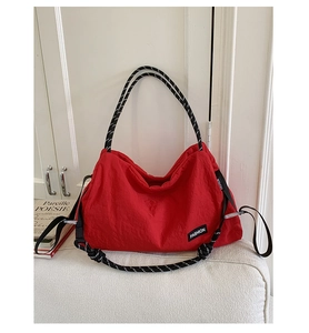 Détail d'un grand sac cabas rouge avec bandoulière en corde tressée et étiquette Fashion