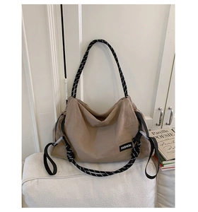 Détail du sac cabas en nylon kaki avec poignées en corde bicolore et étiquette mode