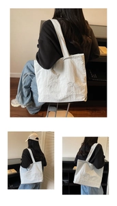 Detalle del bolso tote de lona blanca con bordado delicato de corazón y texto