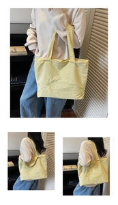 Detalle del bolso tote amarillo con bordado floral y diseño de corazón en tela
