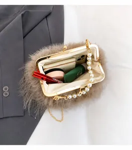 Dettaglio interno spazioso della borsa in peluche con manico di perle e catena
