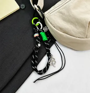 Detail of woven rope keychain with lucky clover charm on a large Oxford fabric bag