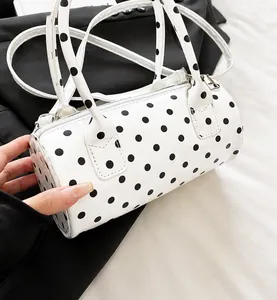 Détail du sac cylindre blanc à pois noirs fabriqué en cuir verni brillant de haute qualité