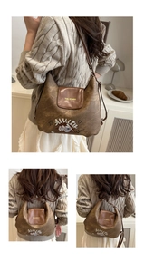 Dettaglio borsa a tracolla marrone vintage con texture in pelle e stampa grafica cartoon