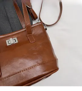 Détail du sac cabas marron vintage montrant la texture du cuir et le fermoir en métal argenté