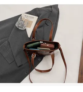 Vue de dessus du sac cabas vintage marron montrant sa grande capacité sur un blazer
