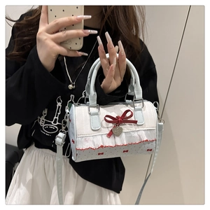 Detailed close-up of blue and white boston bag with lace trim and red bow detail