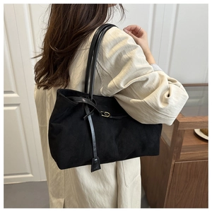 Detail of vintage faux suede tote bag with slim shoulder strap and golden metal buckle