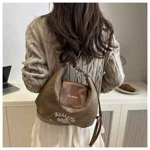 Dettaglio della borsa a tracolla vintage marrone con stampe di cartoni e fibbie in metallo