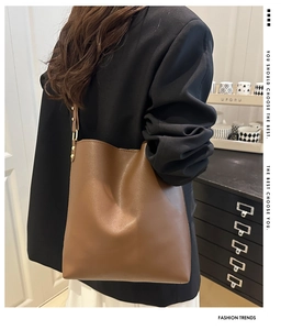 Gros plan du sac seau marron caramel avec boucle dorée et texture en cuir élégante