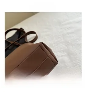 Vue macro des coutures et de la texture cuir mat sur le fond du sac seau marron