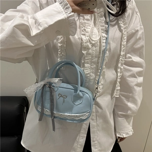 Light blue oval handbag with silver bow detail and lace trim shown in a mirror selfie