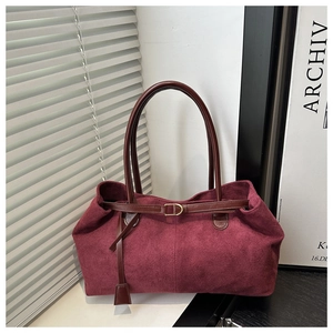 Close-up of retro burgundy suede tote bag showing soft texture and gold D-ring hardware