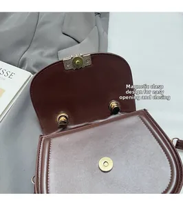 Détail du fermoir magnétique d'une besace en cuir caramel pour une ouverture sûre